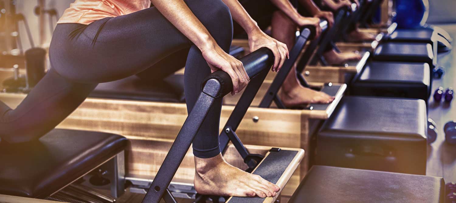 Man on the Reformer machine using Pilates for knee injury | Spine & Sport PT | Rancho Santa Margarita, CA Clinic