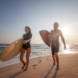 Two surfers on beach after physical therapy