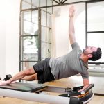 Man on plank in class doing Pilates for core strength exercises | Spine & Sport PT Rancho Santa Margarita Clinic
