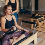 Pilates instructor helps woman with her workout | Spine & Sport PT Rancho Santa Margarita, CA Clinic