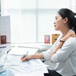 Woman in pain from sitting at work desk | Spine & Sport Physical Therapy | San Diego, Irvine, Sacramento, CA